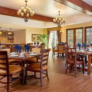 A cozy restaurant dining area with elegant chandeliers and wooden furniture.