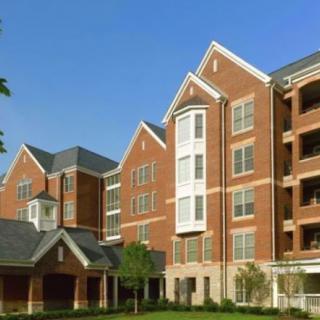 A modern brick apartment complex with multiple stories and traditional architectural elements.