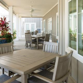 An inviting outdoor patio with dining tables, chairs, and potted plants.