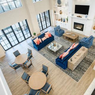 A modern and spacious living room with stylish furniture, featuring a fireplace and abundant natural light.