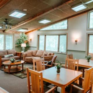 A cozy living room with wooden furniture and ample natural light.