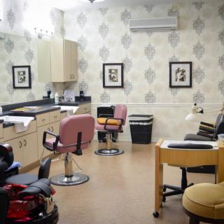 A cozy and stylish beauty salon interior with chairs and equipment.