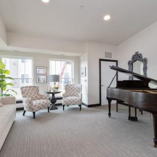 A stylish living room featuring a grand piano and cozy seating area.