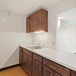 A modern kitchen with wooden cabinets and a white countertop.