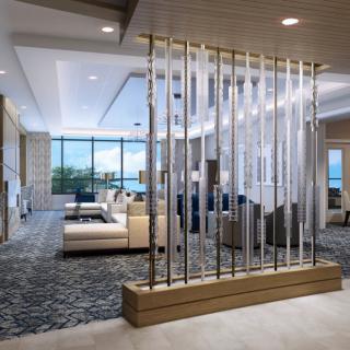 A modern and spacious lobby with elegant furniture and a glass partition.