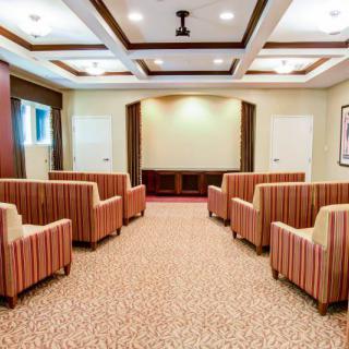 A well-lit conference room with comfortable seating arranged in rows.