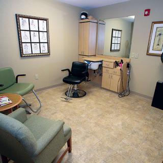 A cozy waiting area in a hair salon with seating and a mirror.