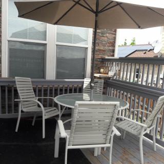 Outdoor patio area with a table, chairs, and an umbrella on a deck.