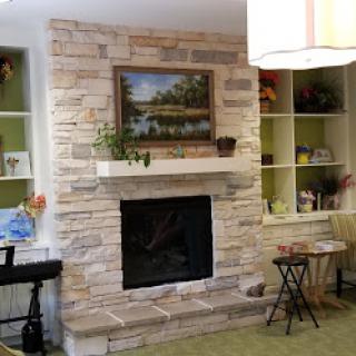Cozy living room featuring a stone fireplace and vibrant green accents.