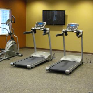 A gym room featuring two treadmills and an elliptical machine.