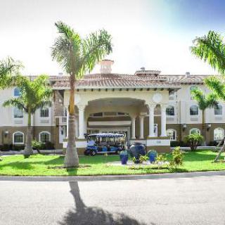 A luxurious resort entrance flanked by palm trees and elegant architecture.