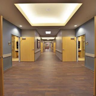 A well-lit hallway with multiple doors on each side.