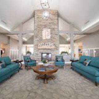 A modern living room with teal sofas and a central fireplace.