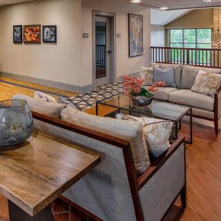 A modern living room with comfortable seating, art on the walls, and wooden floors.