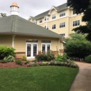 A charming building with well-maintained gardens and a walkway.
