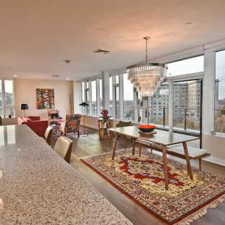 A stylish and modern apartment interior featuring a spacious living and dining area with stunning city views.