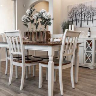 A beautifully decorated dining area featuring a table with white chairs and floral centerpieces.