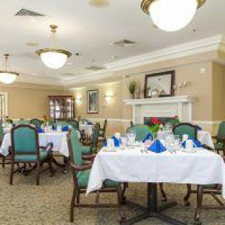 An elegantly decorated dining room with set tables and comfortable chairs.