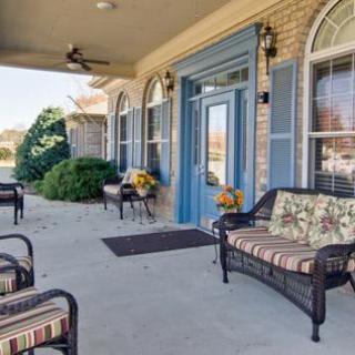 A cozy outdoor patio area with wicker furniture and floral decor.