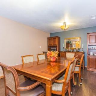 A cozy dining room with a wooden table and chairs, accented by warm lighting and decor.
