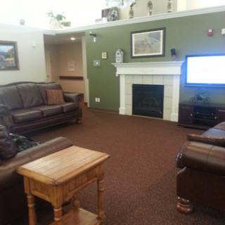A cozy living room featuring leather sofas, a fireplace, and a television.
