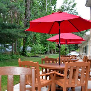 A cozy outdoor seating area featuring wooden furniture and bright red umbrellas.