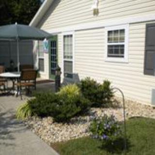 A patio area with outdoor furniture and landscaping in front of a house.