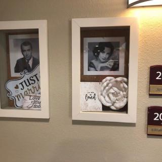 Vintage-style photo frames displayed in a hallway setting, likely part of hotel decor.