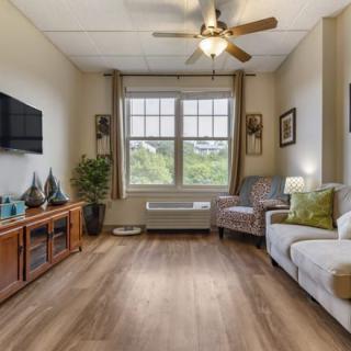 A cozy living room with a large window, television, and comfortable seating arrangement.