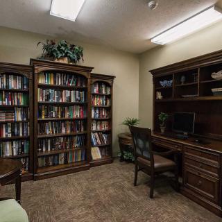 A cozy office with bookshelves and a desk.
