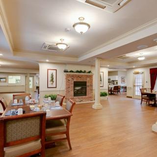 A spacious dining area with elegant furnishings and a cozy fireplace.