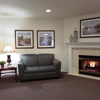 A cozy living room with a fireplace, sofa, and decorative artwork on the walls.