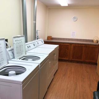 A tidy laundry room with multiple washing machines and a folding area.