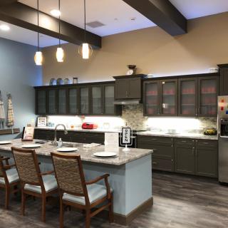 A modern kitchen with a central island, seating, and stylish lighting.