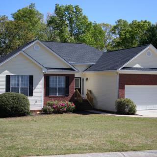 A suburban single-story house with a well-maintained yard.