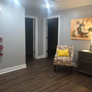 A cozy interior space with a decorative chair, lamp, and wall art.