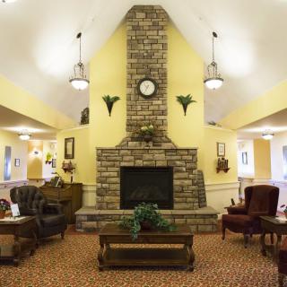 A cozy living room featuring a central brick fireplace surrounded by comfortable seating.