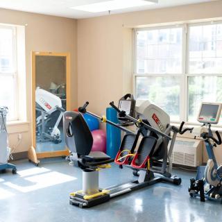 A small gym room with exercise equipment, including a stationary bike and a mirror.