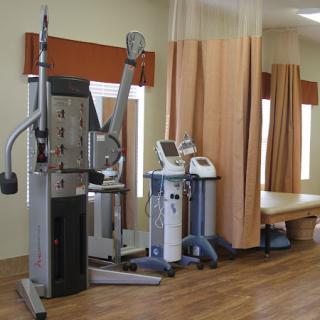 A well-equipped physical therapy room featuring various exercise machines and equipment for rehabilitation.