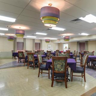 An empty dining hall with multiple tables and chairs arranged neatly.