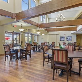 A spacious dining area with wooden beams and elegant chandeliers.