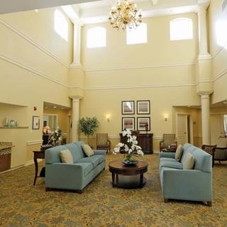 A spacious and elegantly decorated lobby with comfortable seating and a chandelier.