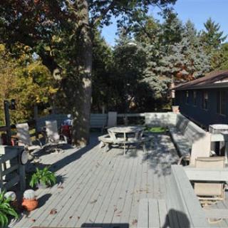 A spacious outdoor deck surrounded by trees, complete with patio furniture for relaxation.