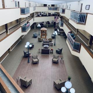 An interior view of a multi-story atrium with seating and lighting arrangements.