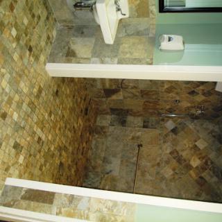 A modern bathroom featuring tiled floors and walls.