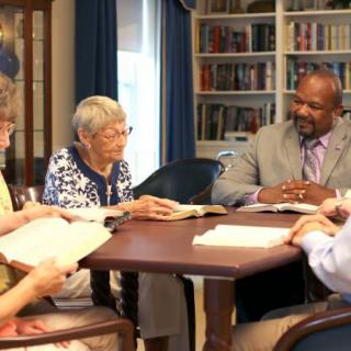 A group of people engaged in a book discussion at a library.