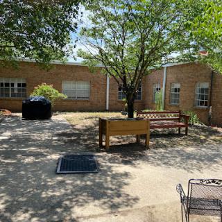 A peaceful courtyard with benches and trees providing shade.