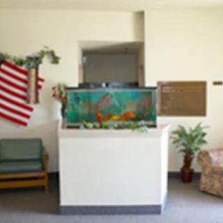 A small waiting area featuring a fish tank, American flag, and seating.