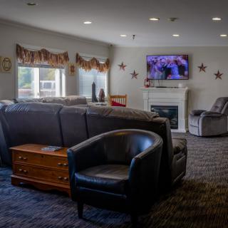 A cozy living room with a fireplace and television, furnished with comfortable seating.