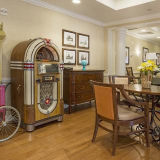 A cozy dining area featuring a vintage jukebox and classic furniture on a wooden floor.